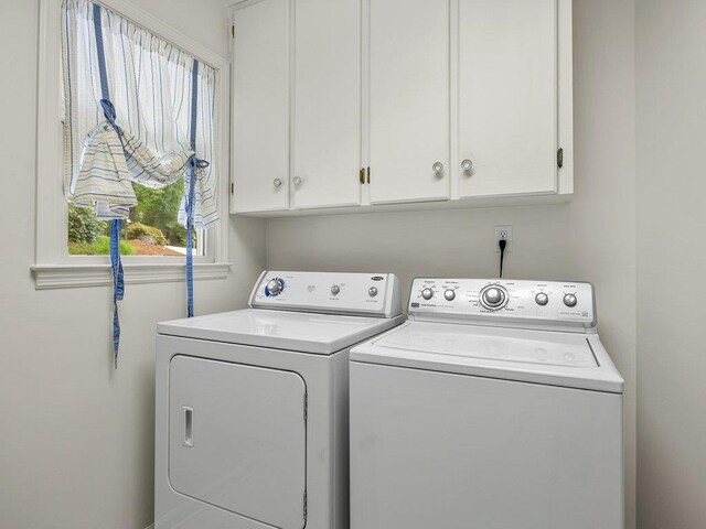 laundry room with washing machine and dryer and cabinet space