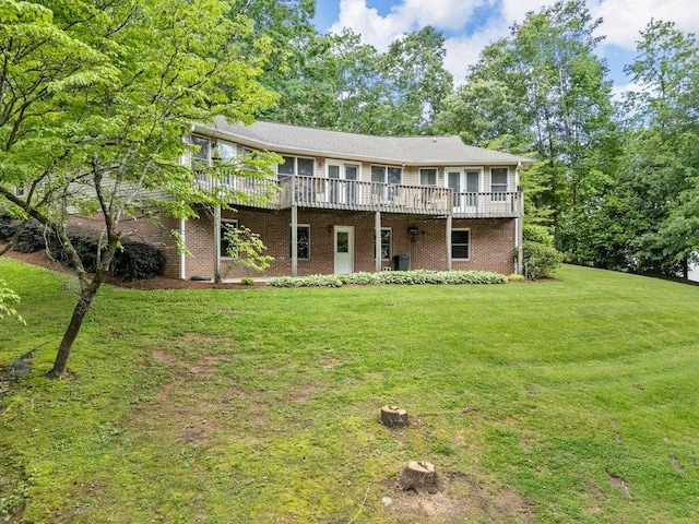 view of front of house featuring a front yard, brick siding, and a wooden deck