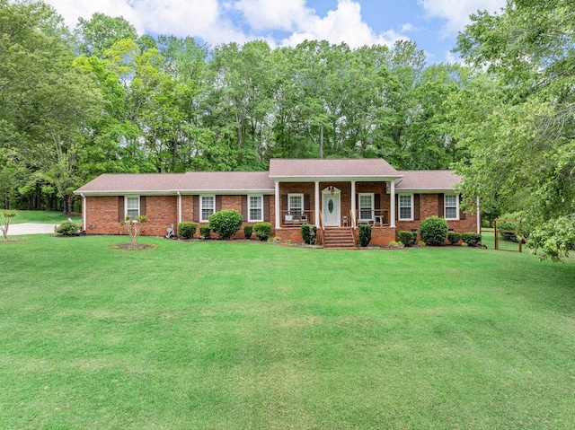 view of front facade with covered porch, brick siding, and a front lawn