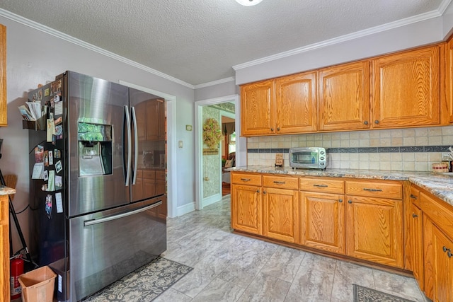 kitchen with brown cabinetry, backsplash, and stainless steel fridge