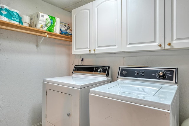 clothes washing area featuring separate washer and dryer and cabinet space