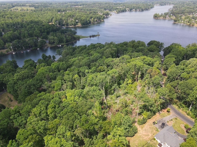 birds eye view of property featuring a wooded view and a water view