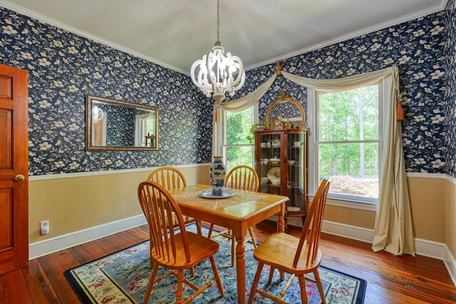 dining room featuring crown molding, a chandelier, wood-type flooring, and wallpapered walls