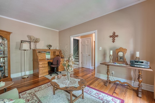 office area featuring baseboards, crown molding, and wood finished floors