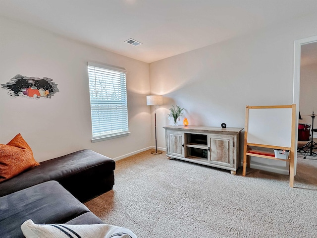 carpeted living area with baseboards and visible vents
