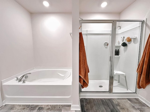 bathroom featuring a stall shower, baseboards, and a bath
