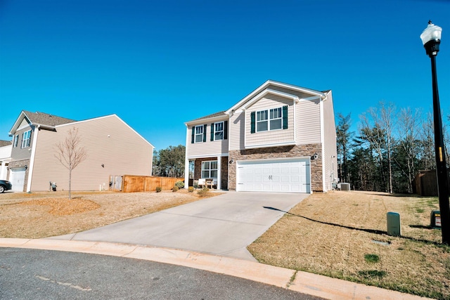 view of front of house featuring stone siding, a garage, central AC, fence, and concrete driveway