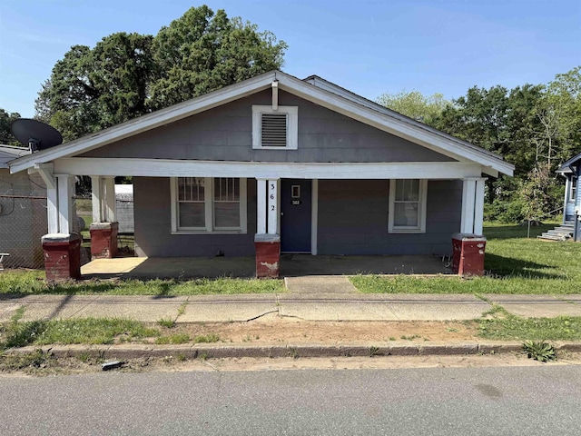 bungalow-style house with covered porch and concrete block siding