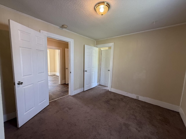 unfurnished bedroom with crown molding, a textured ceiling, baseboards, and carpet