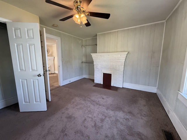 unfurnished living room featuring a ceiling fan, baseboards, visible vents, a brick fireplace, and carpet floors