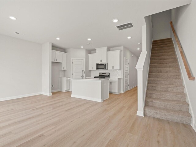 124 Arrow, Greer, SC 29651 - kitchen with stainless steel appliances, white cabinetry, a center island with sink, light wood finished floors, and recessed lighting