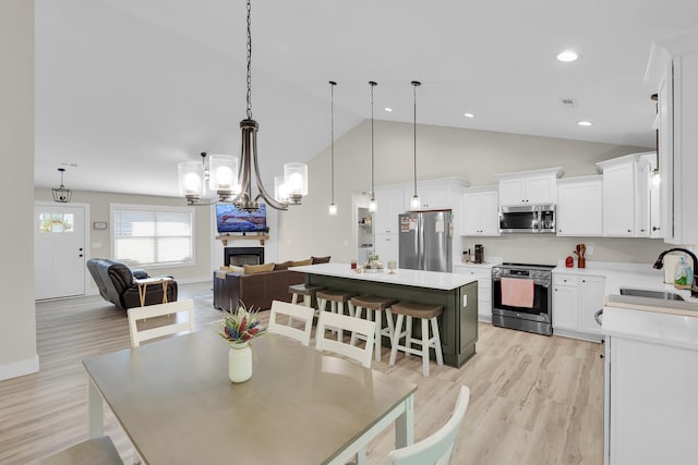 555 Canewood, Campobello, SC 29322 - dining space featuring light wood-style flooring, high vaulted ceiling, a fireplace, a notable chandelier, and recessed lighting