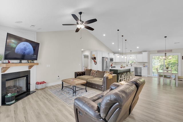 555 Canewood, Campobello, SC 29322 - living area featuring a ceiling fan, high vaulted ceiling, baseboards, a large fireplace, and light wood-style floors