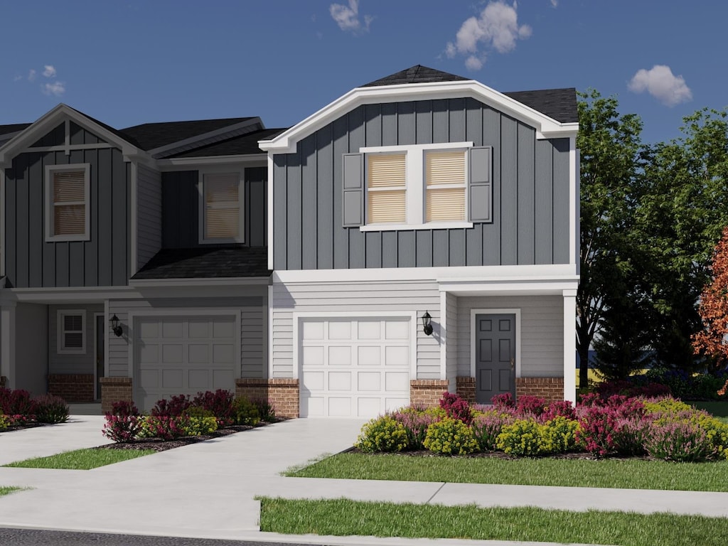 view of front of house with an attached garage, board and batten siding, and brick siding