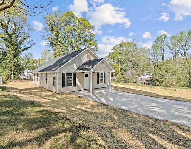 back of property featuring concrete driveway and a patio area