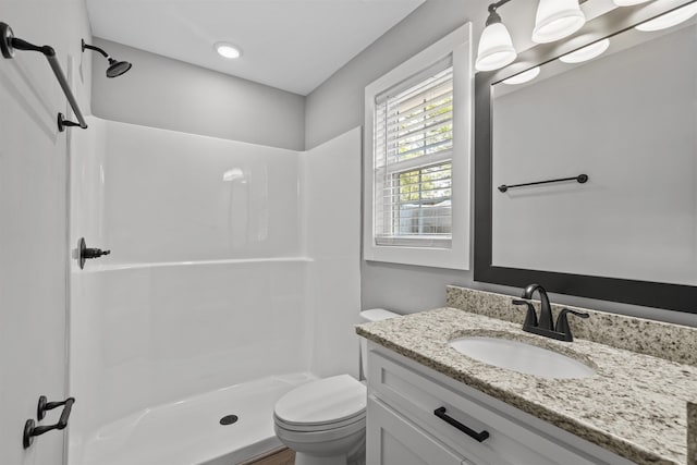 bathroom with vanity, toilet, and a shower stall