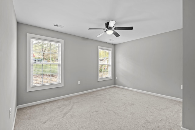 carpeted empty room featuring ceiling fan, baseboards, and visible vents