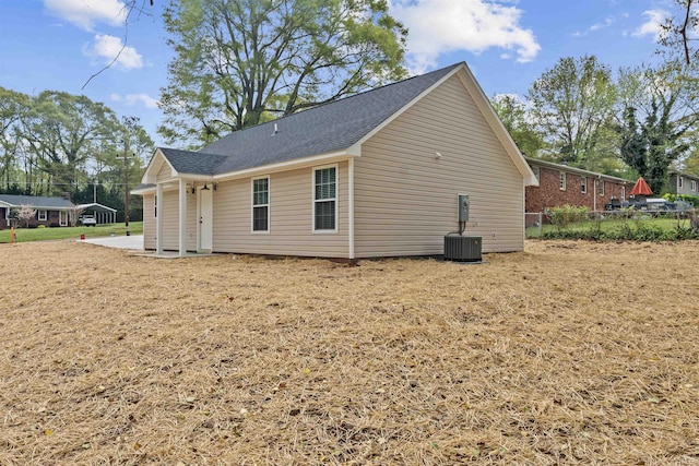 view of home's exterior with fence and a shingled roof