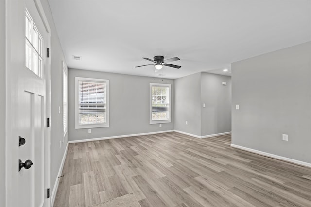 empty room featuring light wood-type flooring, visible vents, baseboards, and a ceiling fan