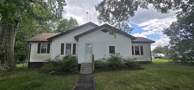 view of front of home with a front lawn, metal roof, and entry steps