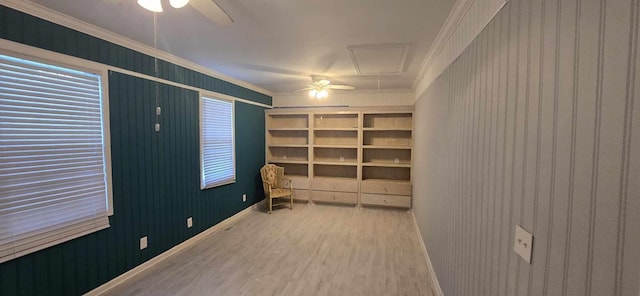 empty room featuring crown molding, attic access, a ceiling fan, and wood finished floors