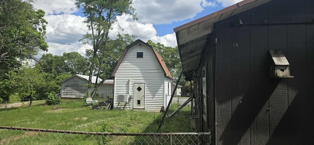 view of property exterior featuring a yard, fence, and a gambrel roof