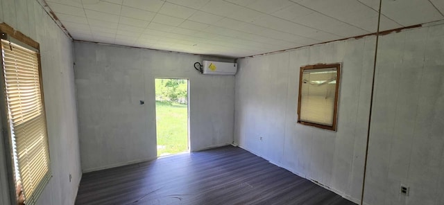 spare room featuring wood finished floors and an AC wall unit