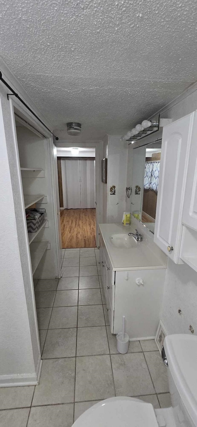 bathroom with tile patterned floors, vanity, and a textured ceiling