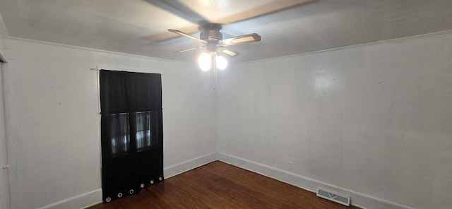 empty room featuring baseboards, visible vents, wood finished floors, and a ceiling fan