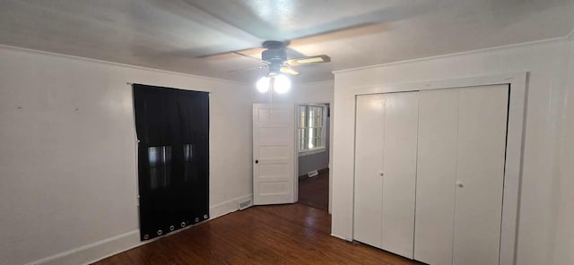 unfurnished bedroom featuring a closet, wood finished floors, ornamental molding, visible vents, and ceiling fan