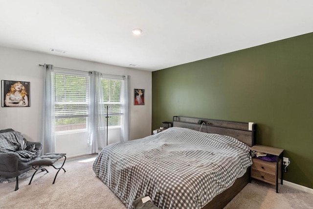 bedroom featuring baseboards, light carpet, and visible vents