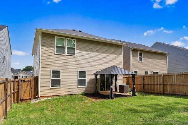 back of property featuring a yard, a gazebo, cooling unit, and a fenced backyard