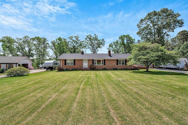 single story home featuring brick siding, a chimney, and a front yard