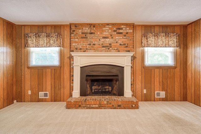 unfurnished living room featuring carpet, plenty of natural light, and visible vents