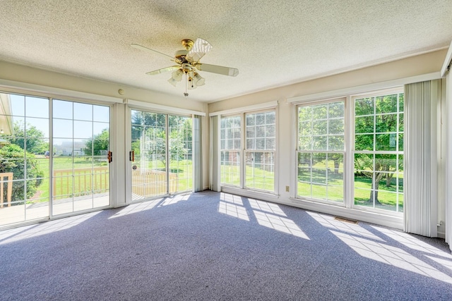 unfurnished sunroom with carpet flooring, visible vents, and a textured ceiling