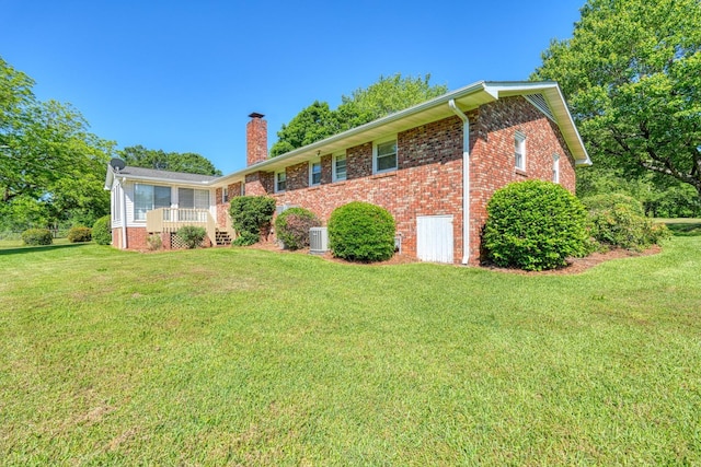 ranch-style house with brick siding, a front lawn, and a chimney