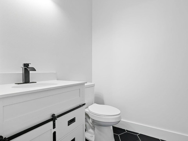 bathroom with toilet, tile patterned flooring, and vanity