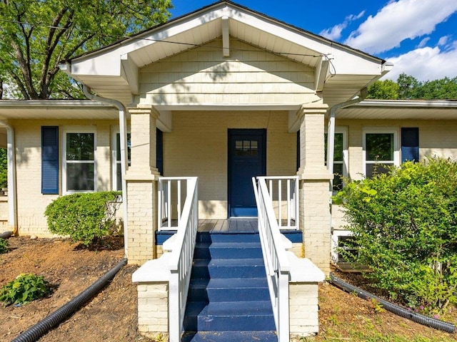 view of front of house featuring a porch and brick siding