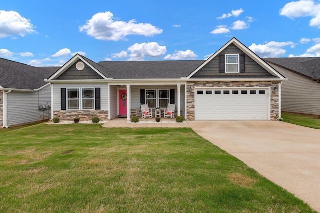 view of front of house with stone siding, concrete driveway, a porch, a front yard, and a shingled roof