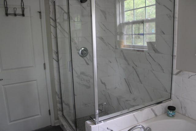 bathroom with a shower stall and a garden tub