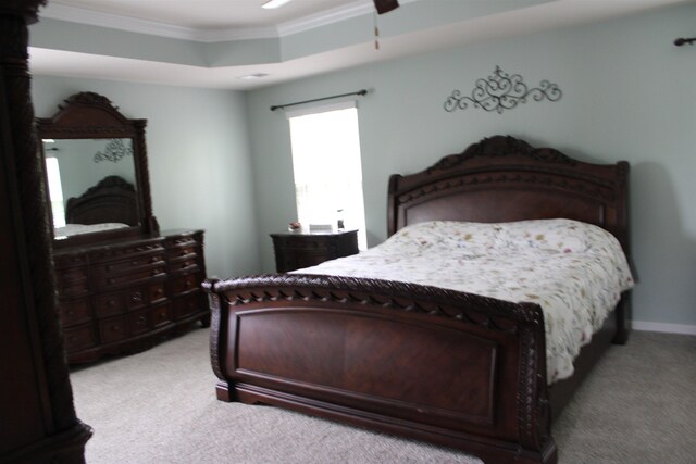 bedroom featuring light carpet, crown molding, a raised ceiling, and baseboards