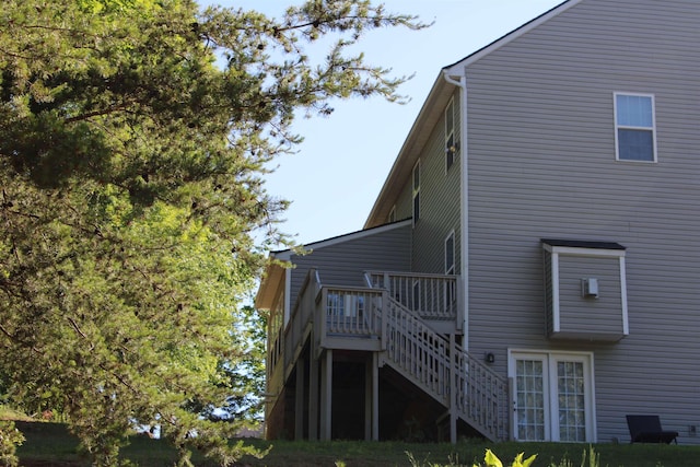rear view of property featuring stairway and a wooden deck