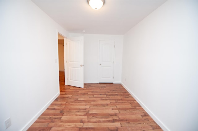 empty room with light wood-style floors and baseboards