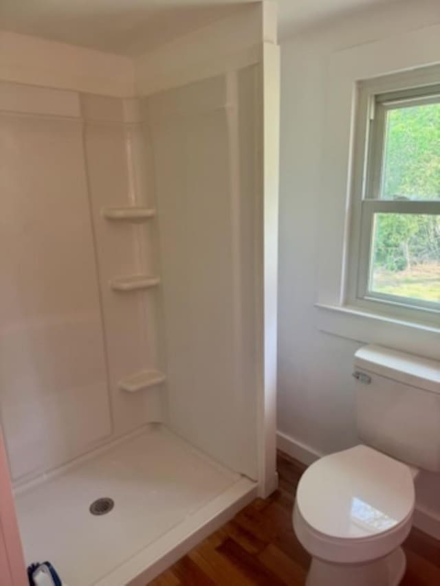 full bath with wood finished floors, toilet, a shower stall, and baseboards