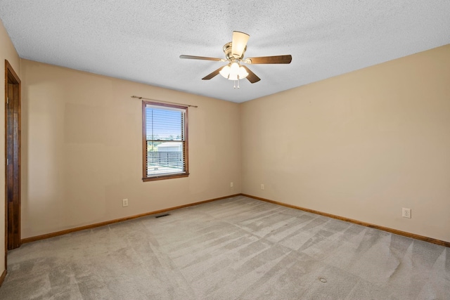 carpeted empty room featuring a ceiling fan, baseboards, and a textured ceiling