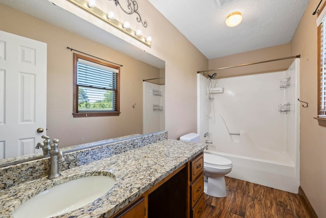 full bath with wood finished floors, vanity, toilet, and shower / washtub combination
