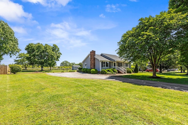 view of property exterior with a chimney and driveway