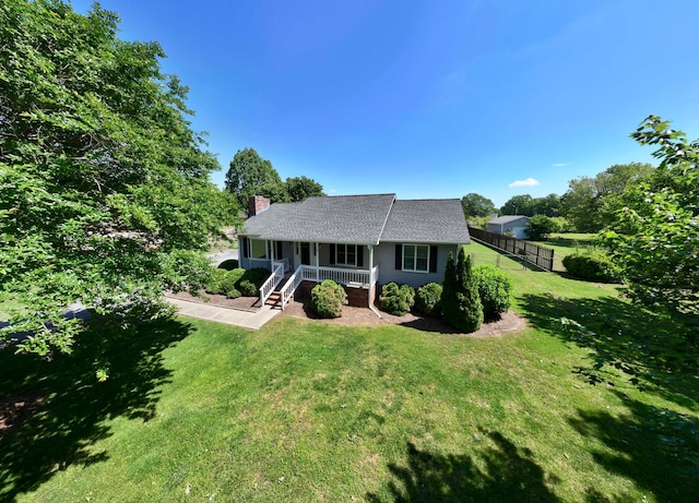 view of front of home featuring covered porch, a chimney, and a shingled roof