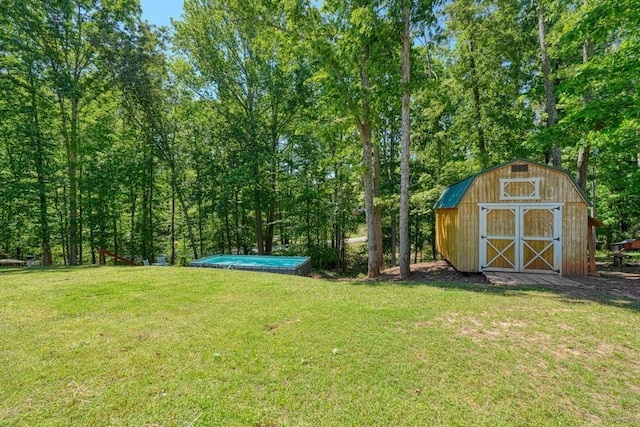 view of grassy yard featuring a shed and an outbuilding