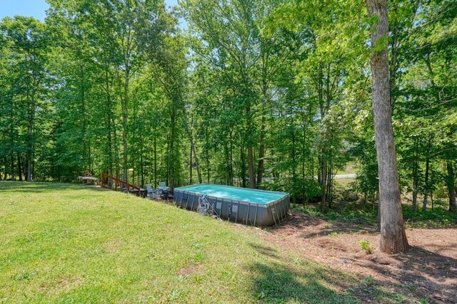 view of grassy yard featuring an outdoor pool